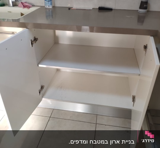 ארון מטבח פתוח עם מדף ריק ומשטח עבודה